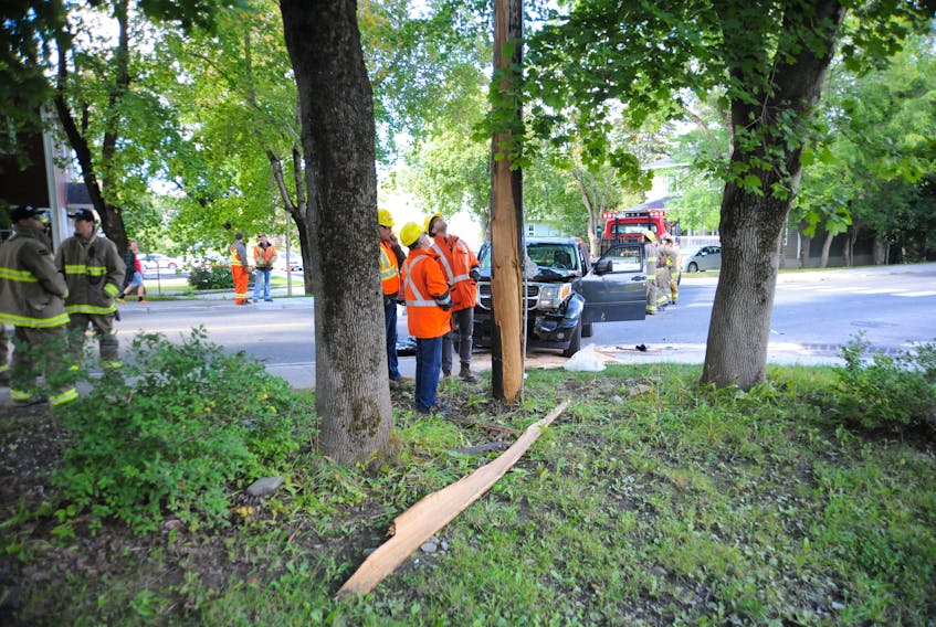 Workers from Newfoundland Power survey the damage to a utility pole caused by an accident at the intersection of Elswick Road and O'Connell Drive Monday afternoon.