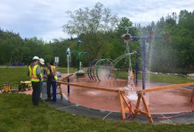 City of Corner Brook employees, from left, Evan Fisher, Jason Tizzard and Donny Wareham, work on fine-tuning the new splash pad at Margaret Bowater Park late Friday afternoon.
