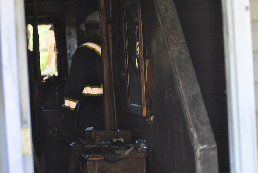 An investigator with the Royal Newfoundland Constabulary is seen inside a home on Hendon Drive in Corner Brook that was extensively damaged by fire on Thursday evening.
