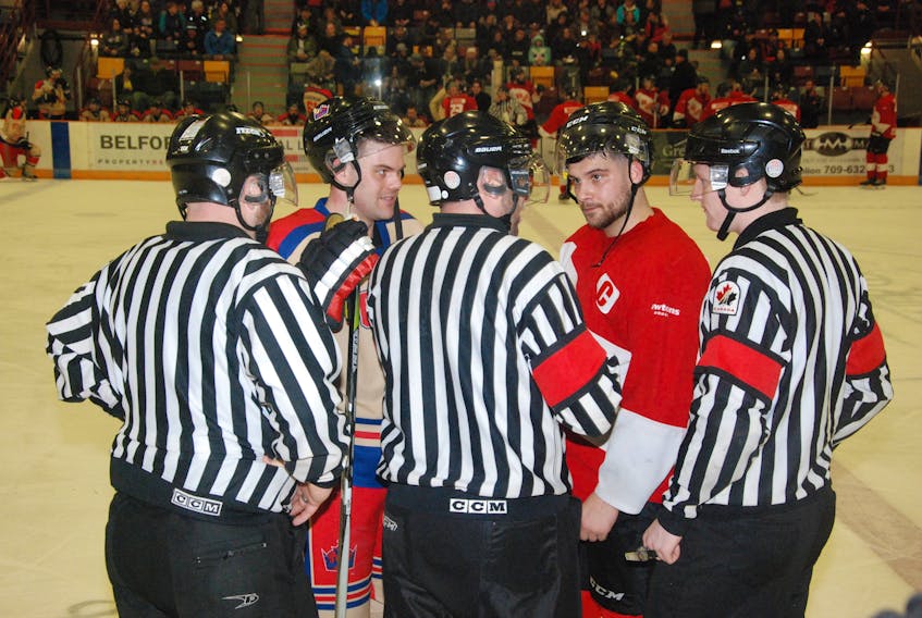 Referees Steven Reid, middle, and Dean Smith and linesman Darren Gillard chat with Steven Simms of the Red Wings and Alex Hillier of the Royals about penalties called after a number of fights broke out in the second period of Friday's West Coast Senor Hockey League playoff game