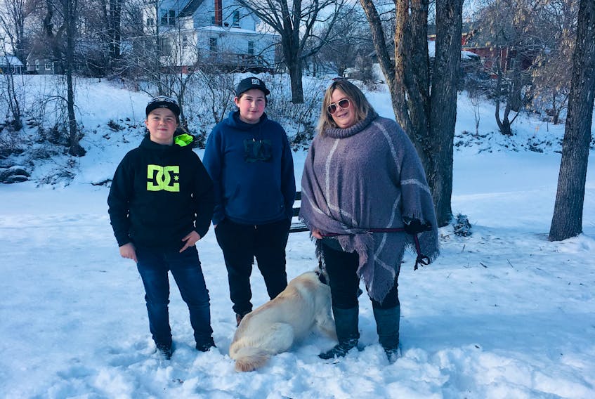 Susan Atkinson and her dog Stormy are safe and sound thanks to 11-year-old Taylor Millett, left, and 13-year-old Jonah MacIntyre who, after hearing her cries of help, pulled Atkinson and her dog up onto the shore from the icy river.