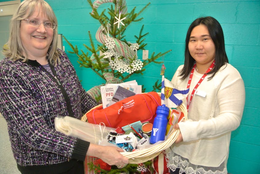 Lisa Emery (left) and Hee Yeon Son from the Multicultural Association of Cumberland County show off one of the welcome baskets the organization has prepared for new Canadians settling in the area. The group started with 12 baskets and has given out seven. The baskets include local products such as jam and honey as well as information about local programs and services.