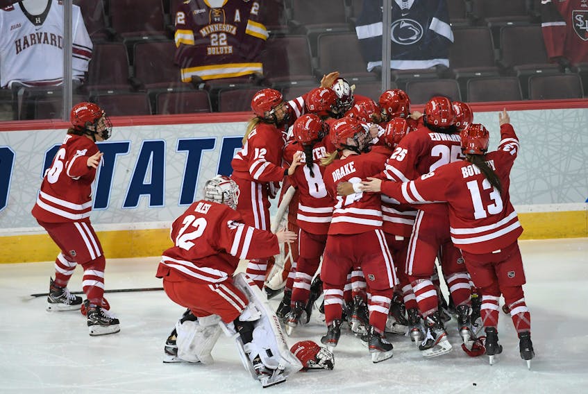 The Wisconsin Badgers celebrate after Daryl Watts scored the overtime winner Saturday night in the final of the NCAA women's hockey championship against the Northeastern Huskies in Erie, Pa. - University of Wisconsin