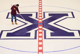 Terwin Branzuela rolls the edges on the StFX hockey logo at centre ice at the Keating Centre. The lines and logos were installed on Thursday, Sept. 24, as optimism abounds for a new season of men’s and women’s AUS hockey.