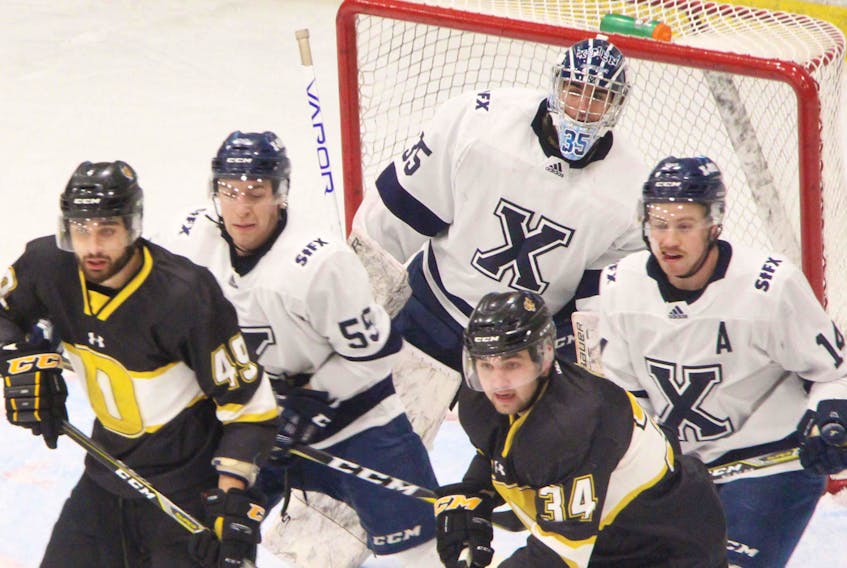 St. F.X. X-Men goaltender Chase Marchand trying to find a sightline as teammates Aaron Hoyles (#55) and Matt Needham look to contain Dalhousie Tigers forwards Mike Evelyn and Kelly Bent, in first-half Atlantic University Sport (AUS) hockey action at the Keating Centre. Richard MacKenzie