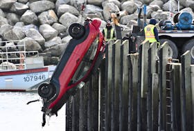 A vehicle is lifted out of the water at the Cape St. Mary's wharf in Digby County the morning of Sunday, March 1. On Facebook a video was posted of someone purposely crashing the vehicle through the wooden piles, sending the vehicle into the water. A person emerges safely from the vehicle after it submerges. TINA COMEAU PHOTO