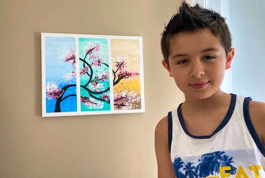 Kai Vo, an 8-year-old artist, with his first painting.