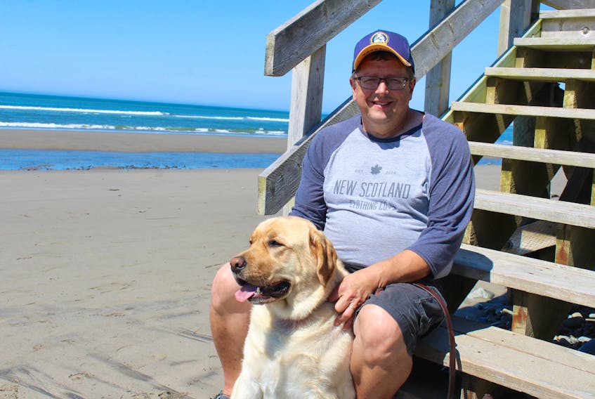 Marc Brophy and his dog Duke at Port Maitland Beach.