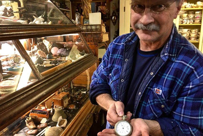 Kevin Selig, owner of Warehouse 87 Antique Emporium on Water Street, holds a pocket watch similar to five he sold for the filming of The Lighthouse.
