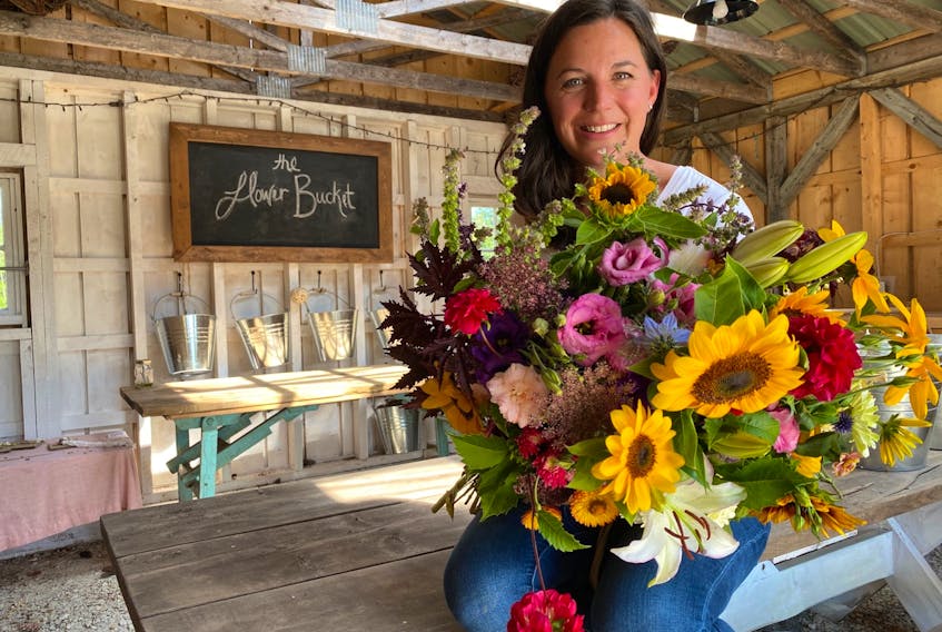 Owner Lisa Fordham with a bouquet of flowers at The Flower Bucket.