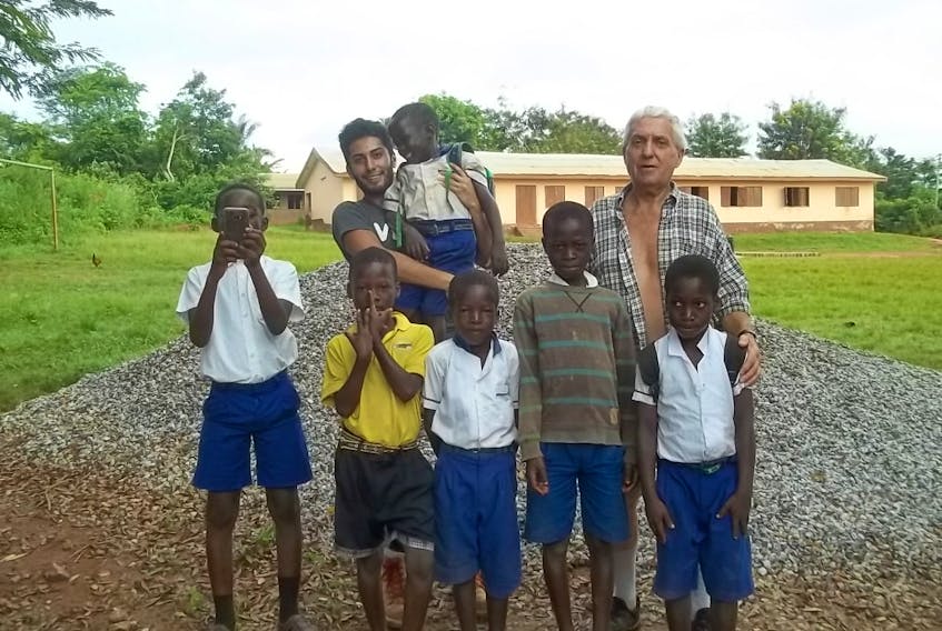 At their job site in Ghana, Julien Comeau (back, right) and a volunteer from Ecuador with some local youths.