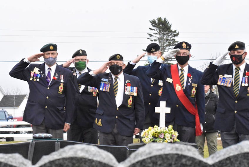 Members of Wedgeport Legion Branch 155 salute as Canadian flags are placed on the graves of veterans in a cemetery in Pinkney's Point, Yarmouth County, on Nov. 6. TINA COMEAU PHOTO