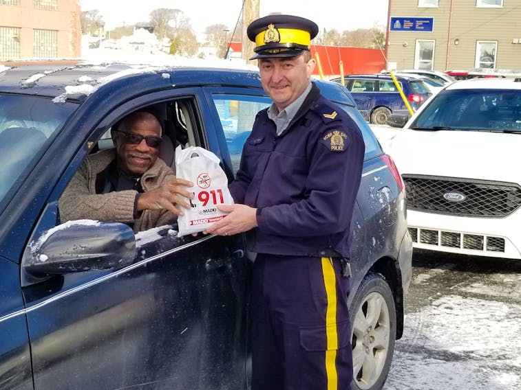 Keith Miller receives a treat bag from Cpl. Terry Burridge with the Yarmouth Town Detachment.
