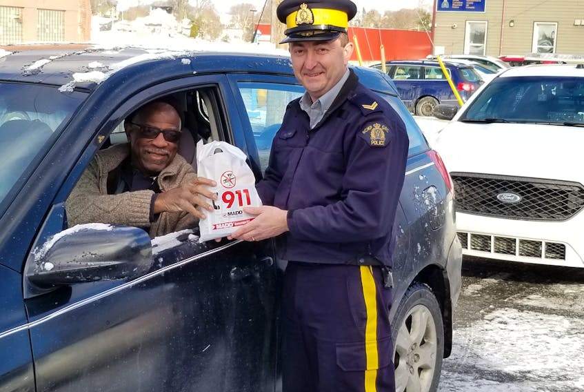 Keith Miller receives a treat bag from Cpl. Terry Burridge with the Yarmouth Town Detachment.