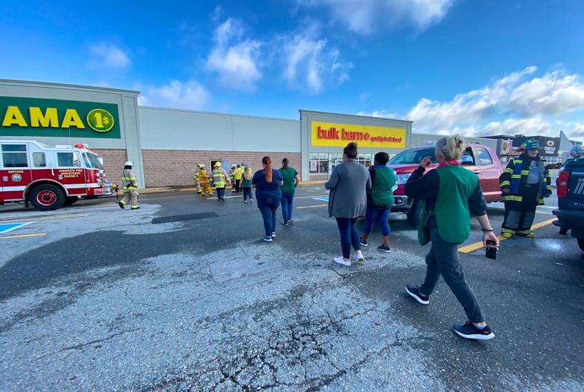 Yarmouth Dollarama staff and firefighters outside the Yarmouth business the morning of Oct. 22 after a fire at the business. CARLA ALLEN PHOTO