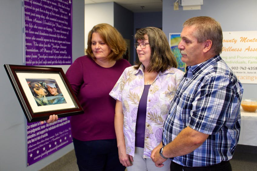 Brenda Martin-Hurlburt (left) holds a picture of Jocelyn Stewart and her dog, Amani, while Jocelyn’s parents, Sharon and Peter Stewart, look on in Yarmouth following the official launch of the Jocelyn Stewart Foundation.