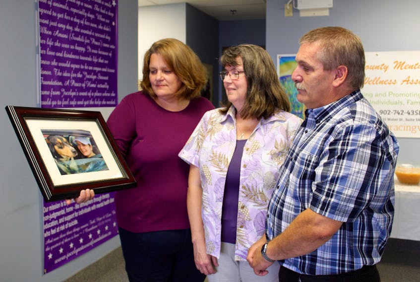 Brenda Martin-Hurlburt (left) holds a picture of Jocelyn Stewart and her dog, Amani, while Jocelyn’s parents, Sharon and Peter Stewart, look on in Yarmouth following the official launch of the Jocelyn Stewart Foundation.
