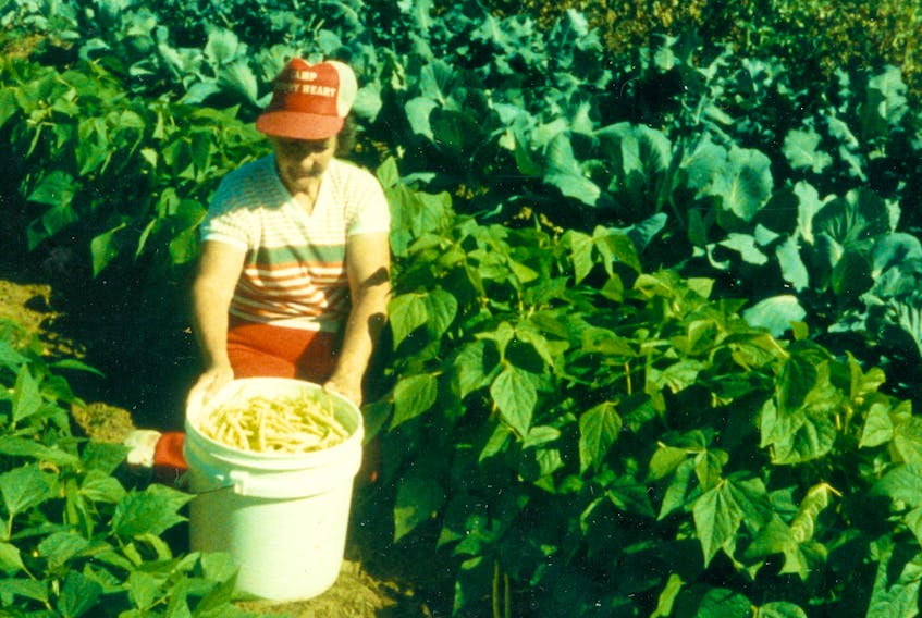 Ethel Cottreau picks a pail of beans from a garden in her past.