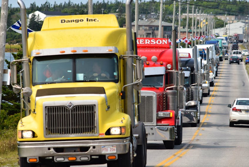 Big rigs roll across the Cape Sable Island Causeway in a memorial convoy for the late Roger James Comeau of Barrington on Aug. 24. Described as a legend, Comeau was on one of his weekly hauls to New York City and New Jersey when he passed away suddenly on Aug. 14 .  KATHY JOHNSON PHOTO