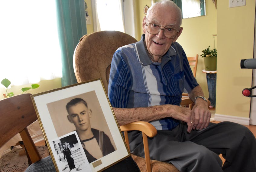 Yarmouth resident Wesley Spinney, now 95, sits next to a photo of a younger version of himself from his days in the Second World War, which included D-Day. TINA COMEAU PHOTO