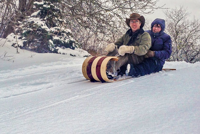 Dan Peacock and his wife Dorothy enjoy some winter fun on one of his handmade toboggans.