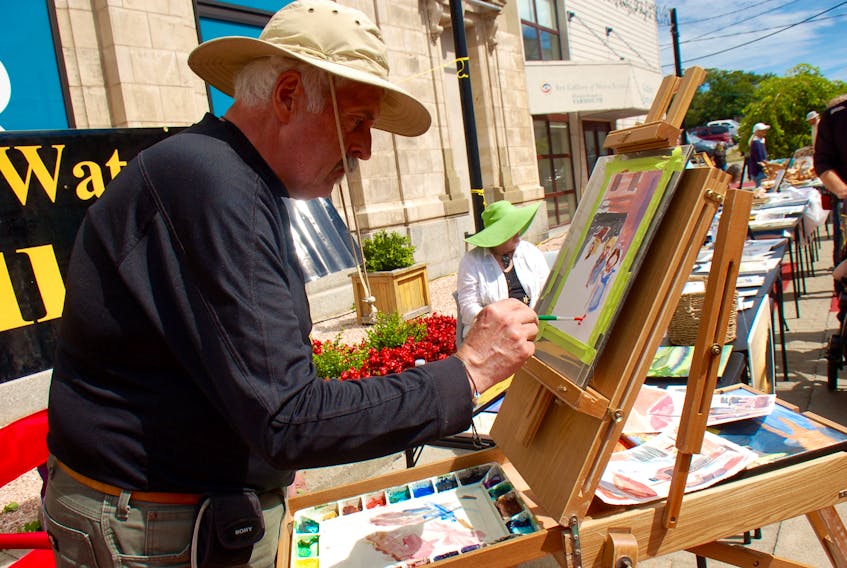 Ivan Ray Blades, a member of the Yarmouth Art Society, paints in Alma Square during a SWITCH event.
