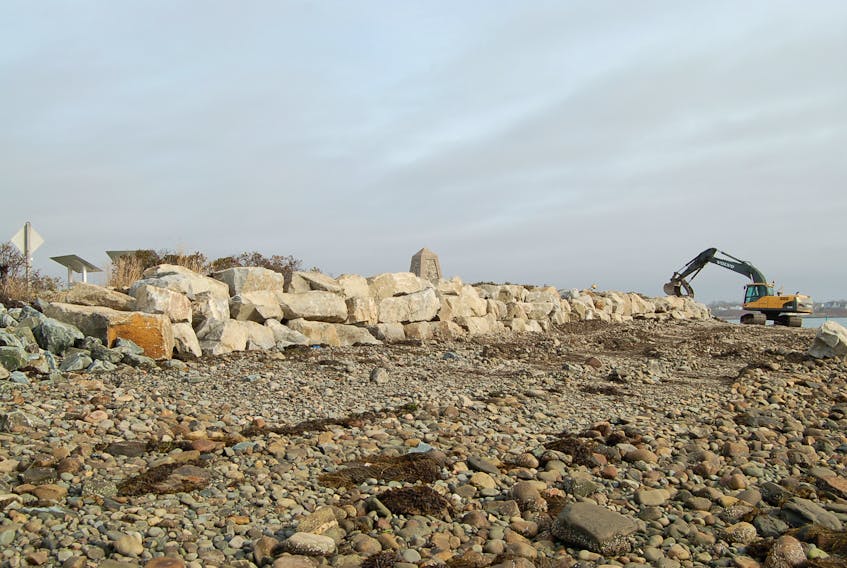 An excavator moves large boulders in place to form a seawall at Fish Point, just before Yarmouth Bar on Hwy. 304.