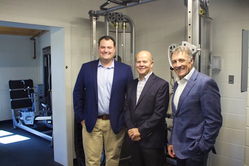 Colin Fraser, Member of Parliament for West Nova, Noel Despres, CEO and President of Comeau's Seafood and Allister Surette, President of Université Sainte-Anne, in the newly renovated weight room, part of the renamed Marcel R. Comeau Sports Centre.