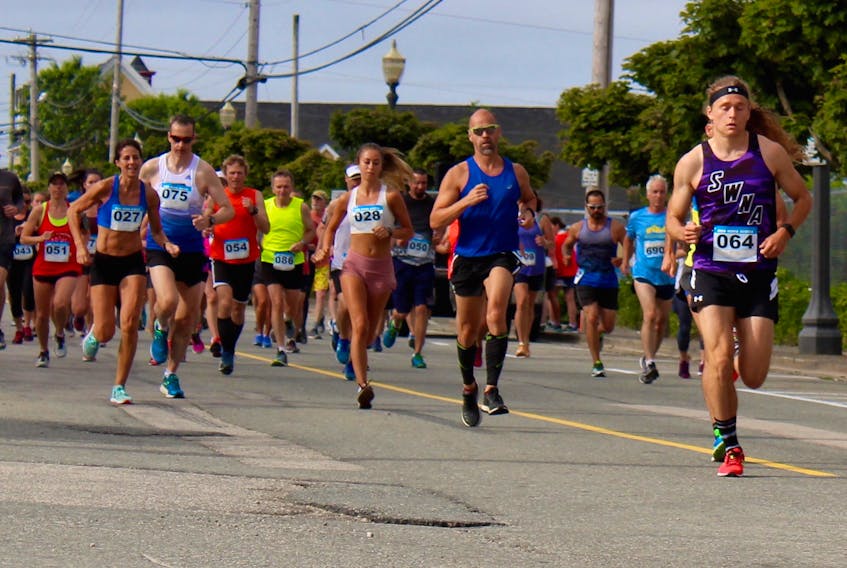 The eventual men's and women's winners are visible in this image from the 2018 Sheila Poole 10K in Yarmouth. On the left side of the shot is Denise Robson (027), now a 12-time Sheila Poole champ, and on the right is Hudson Grimshaw-Surette (064), who led all runners in his Sheila Poole debut.