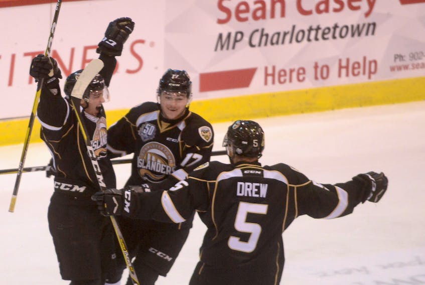 Lukas Cormier, left, celebrates with teammates Liam Peyton and Hunter Drew after scoring the go-ahead goal with six minutes remaining in the third period against the Cape Breton Screaming Eagles Saturday at the Eastlink Centre.