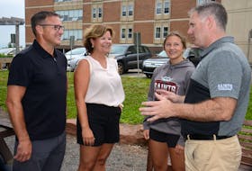 Mount Academy headmaster Kenny MacDougall, right, speaks with the MacDonald family outside the Charlottetown facility. From left are Kent, Bonnie and Tate MacDonald.