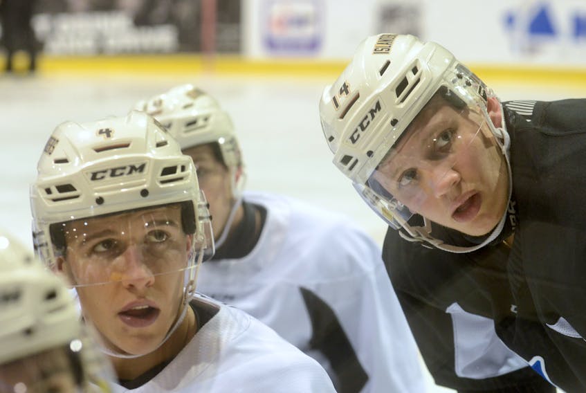 Charlottetown Islanders captain Brendon Clavelle, left, and assistant captain Nikita Alexandrov listen to a drill during Wednesday’s practice at the Eastlink Centre.