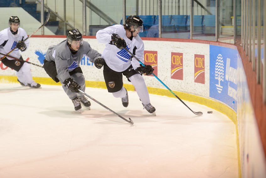 Defenceman Lukas Cormier cycles the puck to a teammate while being defended by Drew Elliott at Monday's Charlottetown Islanders practice at the Eastlink Centre.