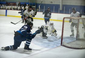 Eastern Express captain Evan Nicholson, left, fires the puck into the Central Attack net during the first period of Tuesday's second game of the P.E.I. Major Under-15 AAA Hockey League semifinal.