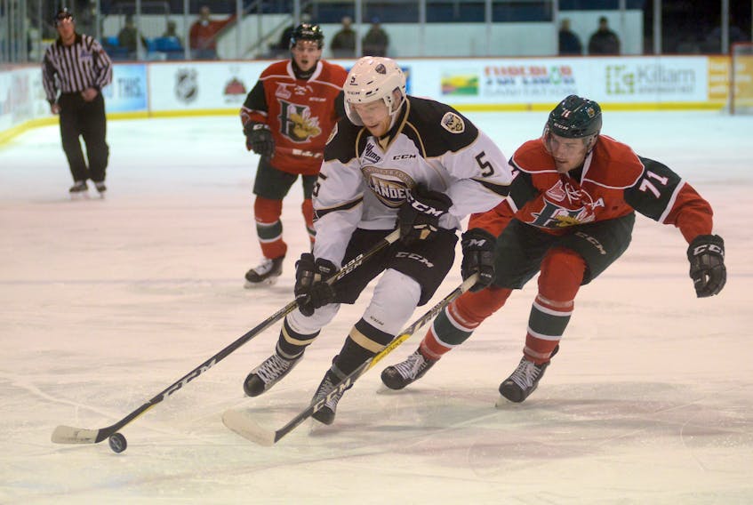 Charlottetown Islanders defenceman Hunter Drew, left, protects the puck from Halifax Mooseheads forward Connor Moynihan during regular season action in February at the Eastlink Centre.