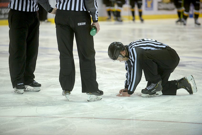 Linesman Tanner Doiron tries to repair a hole in the ice during Tuesday's Quebec Major Junior Hockey League game at the Eastlink Centre.