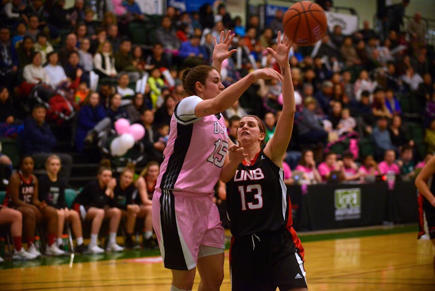 UPEI Panthers centre Carolina Del Santo, left, kicks the ball out to a teammate while being defended by UNB's Krystal Osburn Saturday during Atlantic University Sport women's basketball action in Charlottetown.