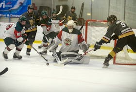 Kensington Monaghan Farms Wild forward Reid Peardon, left, and Charlottetown Bulk Carriers Knights forward Simon Hughes, right, look for a rebound in front of Wild goalie Jonah Arbing Friday at MacLauchlan Arena.