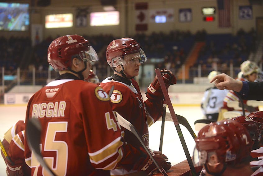 Zach Biggar, left, and Cole Larkin listen to a coach during a game at the Eastlink Centre in the 2019-20 Quebec Major Junior Hockey League season.
