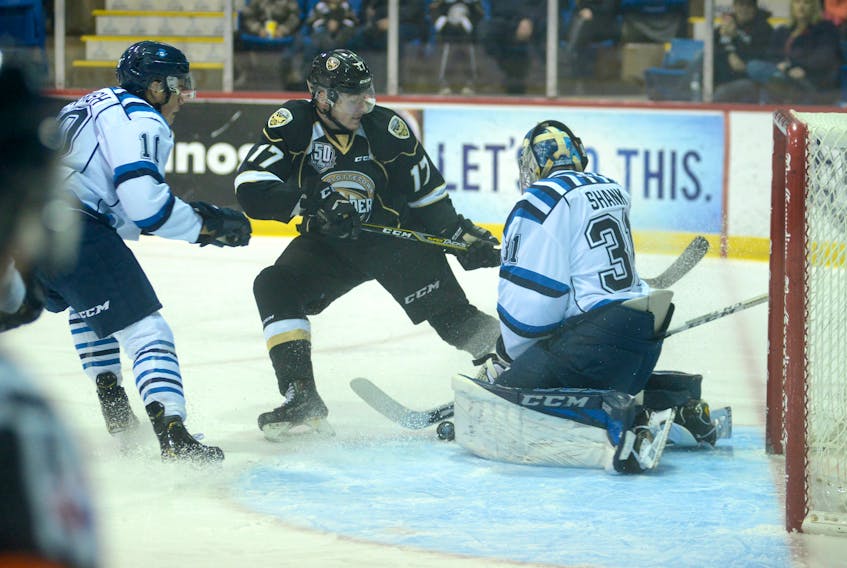 Chicoutimi Sagueneens goalie Alexis Shank makes a save as Charlottetown Islanders forward Liam Peyton goes hard to the net during Friday's Quebec  Major Junior Hockey League contest at the Eastlink Centre.