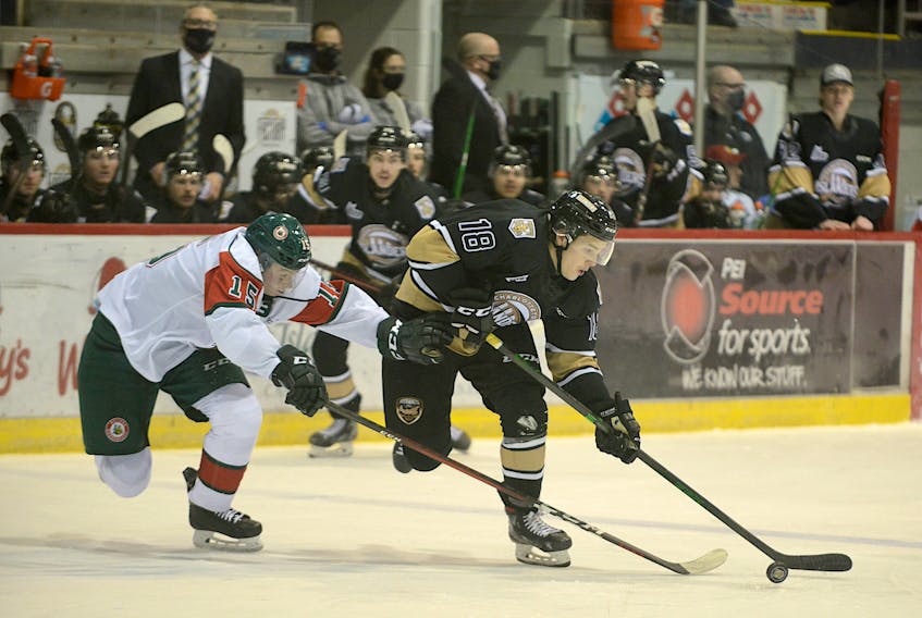 Charlottetown Islanders' centre Justin Gill, right, cuts to the middle on Halifax Mooseheads' defenceman Alexandre Tessier Wednesday at Eastlink Centre.