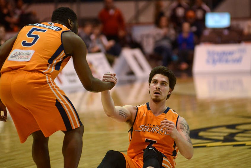 Island Storm guard Kemy Osse, left, helps Brad States up after the forward was fouled during Thursday’s Game 3 against the Halifax Hurricanes at the Eastlink Centre.