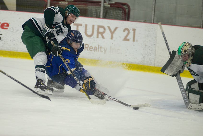 Université de Moncton forward Vincent Deslauriers tries to get a shot off while going hard to the net and being checked by UPEI Panthers defenceman Jesse Annear Wednesday during Atlantic University Sport men’s hockey action in Charlottetown.