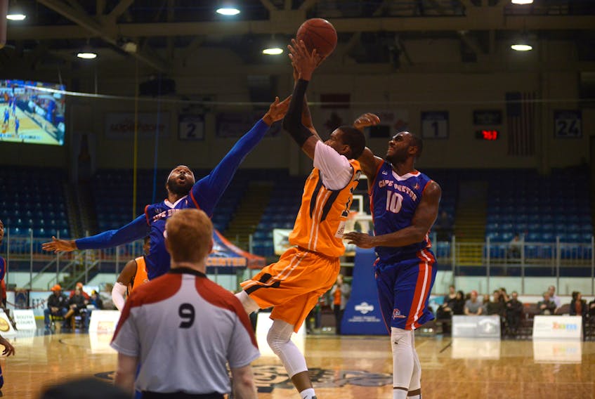 Island Storm forward Du'Vaughn Maxwell, centre, takes a shot while being defended by Cape Breton Highlanders Tydran Beaty, left, and Malik Story Thursday at the Eastlink Centre.