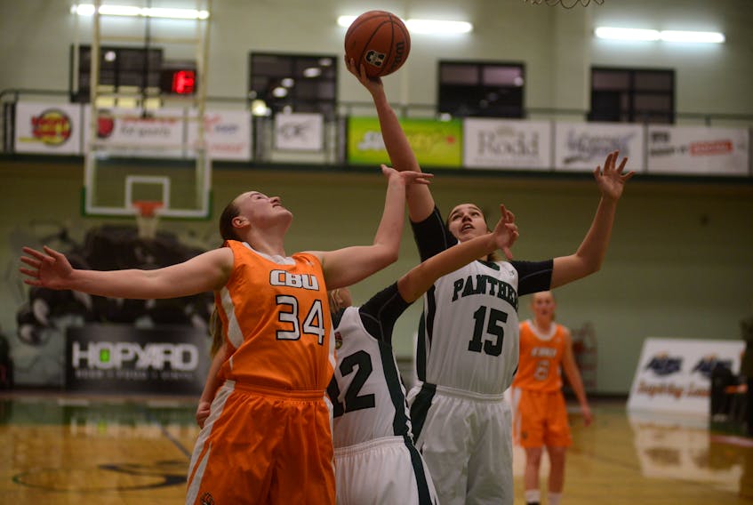UPEI Panthers centre Carolina Del Santo grabs the rebound while teammate Jane McLaughlin boxes out Cape Breton Capers centre Hannah Brown Saturday during Atlantic University Sport women's basketball action in Charlottetown.