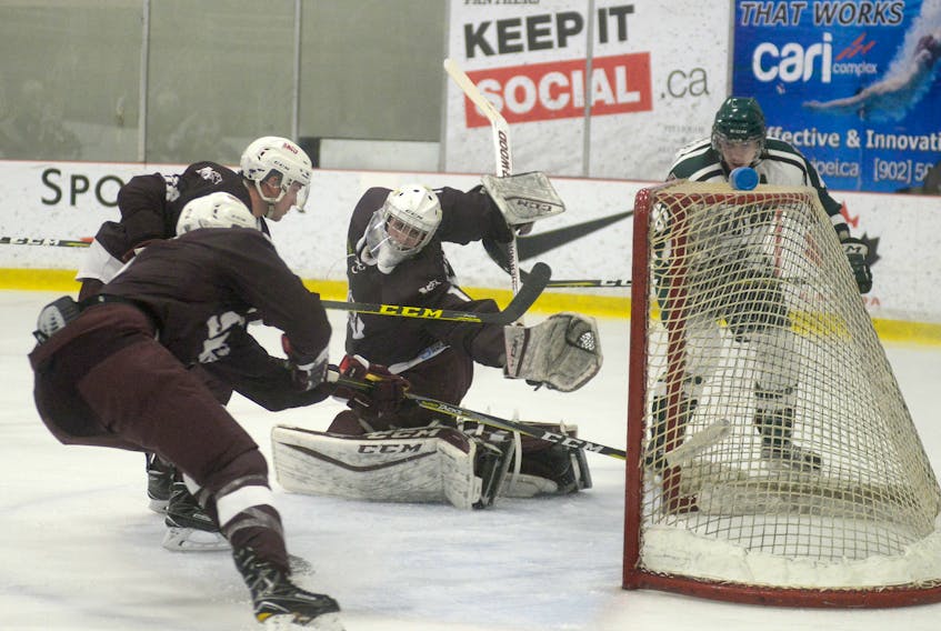 UPEI Panthers defenceman Ryan MacKinnon, right, watches his shot cross the goal-line past Saint Mary’s Huskies goalie Eric Brassard during the first period of Friday’s Atlantic University Sport quarter-final at MacLauchlan Arena A.