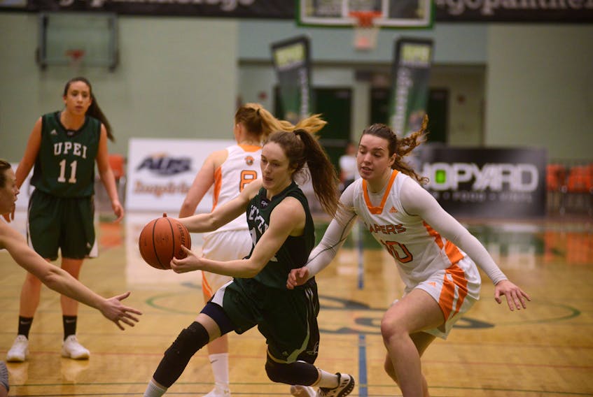 UPEI Panthers guard Annabelle Charron, left, drives past Cape Breton Capers Sarah Hiscock forward Sunday during Atlantic University Sport women’s basketball action in Charlottetown.