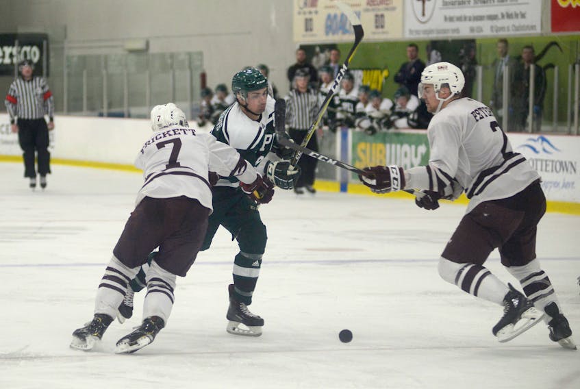 UPEI Panthers captain Brent Andrews chips the puck in and tries to split the Saint Mary's Huskies defence of Mark Trickett, left, and Alexandar Peters Saturday during Atlantic University Sport men's hockey action at MacLauchlan Arena.