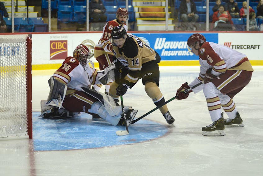 Acadie-Bathurst Titan goalie Tristan Berube makes a save as Charlottetown Islanders centre Nikita Alexandrov cuts to the crease for a shot Saturday during Quebec Major Junior Hockey League action at the Eastlink Centre.