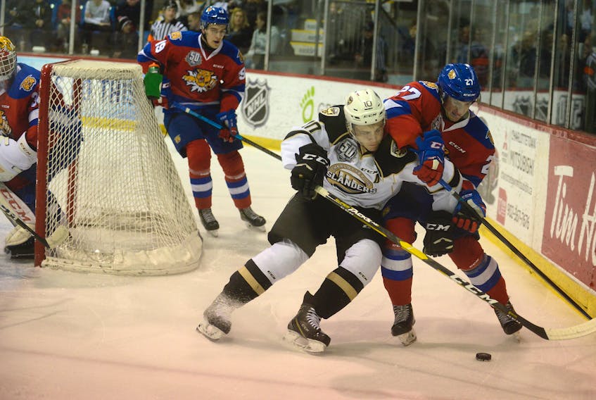 Charlottetown Islanders left-winger Brett Budgell, left, battles Moncton Wildcats defenceman Christian Huntley Friday during the final home game of the Quebec Major Junior Hockey League regular season for the Isles.
